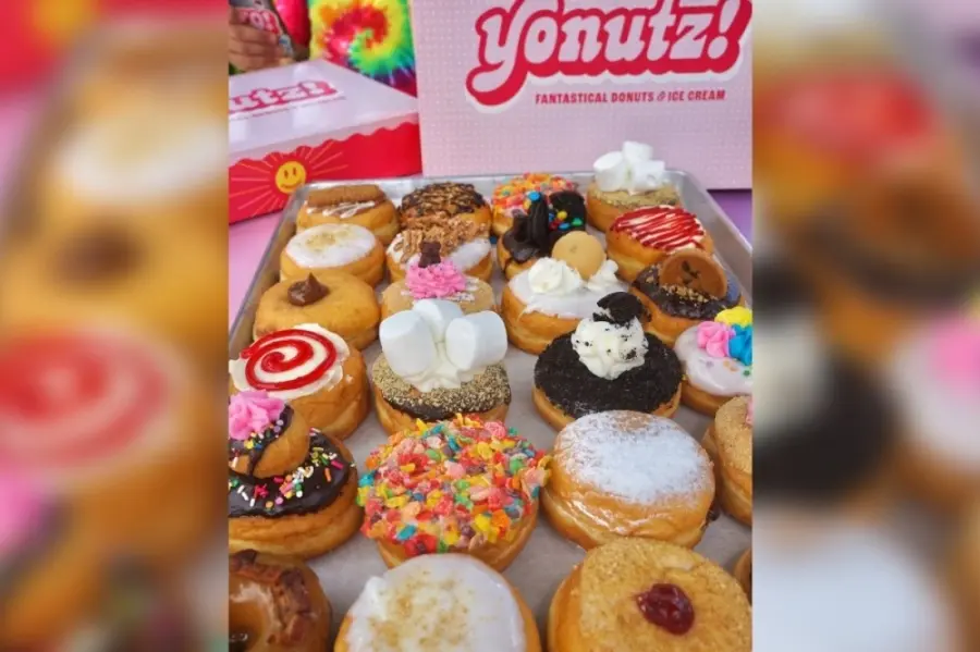 Assorted decorated donuts with toppings including sprinkles, frosting, and jam fillings arranged on display