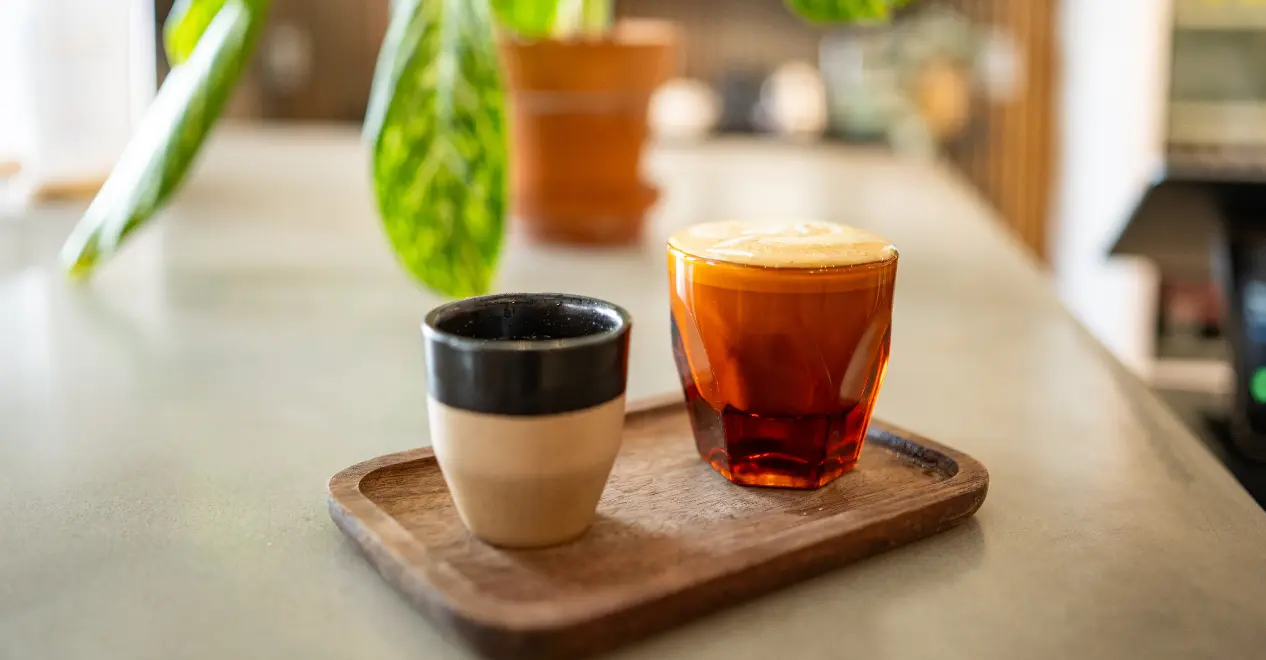 Two hot coffee lates on a wooden tray from Filtered Coffee Shop