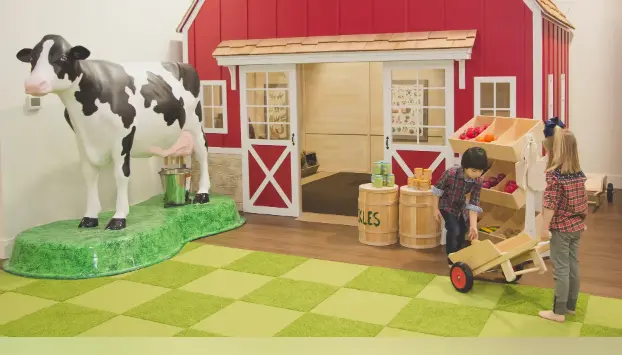 Kids playing in a museum with different animal farm items