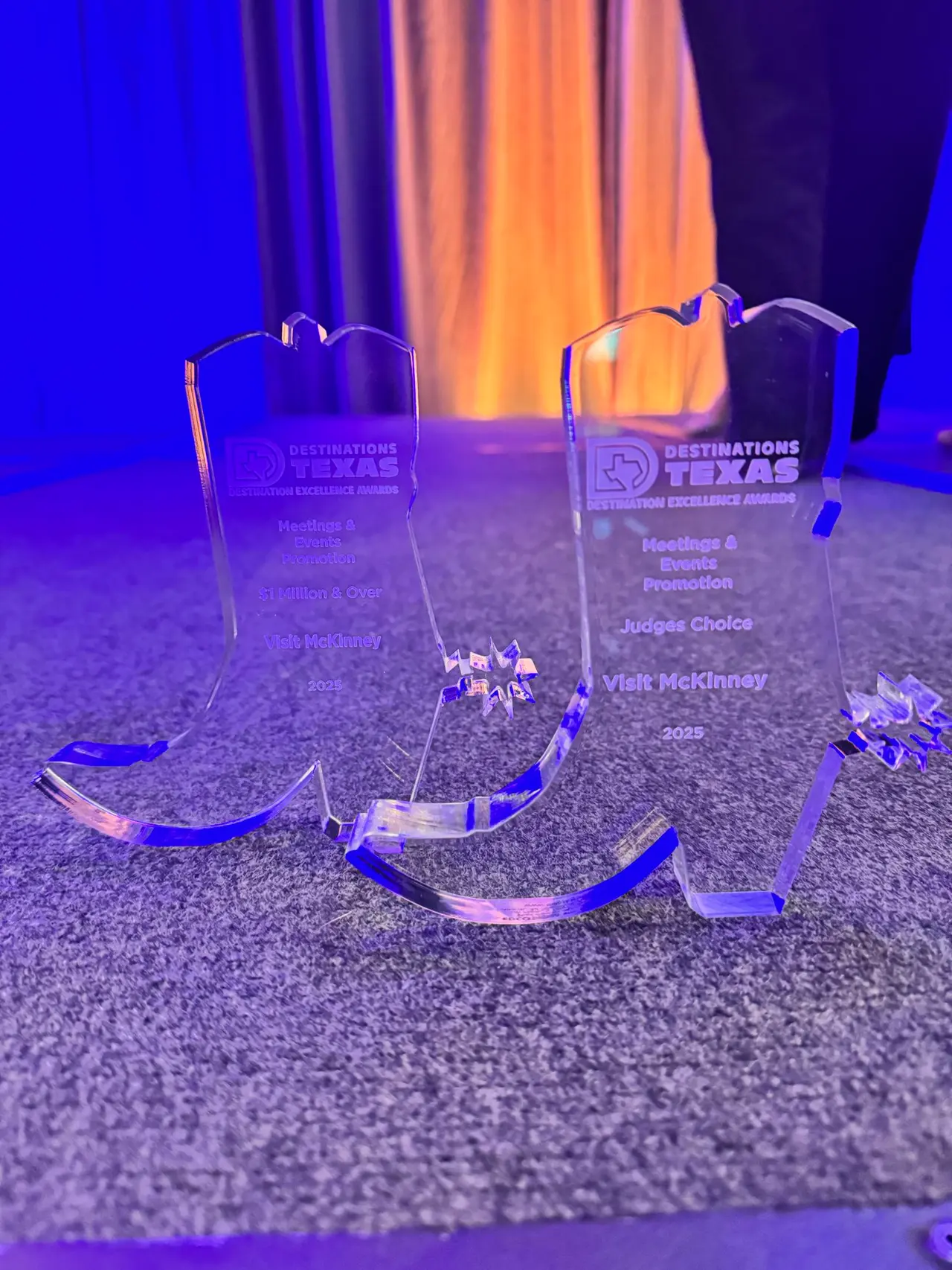 Two clear award plaques in the shape of boots for Best Promotions and Events categories.