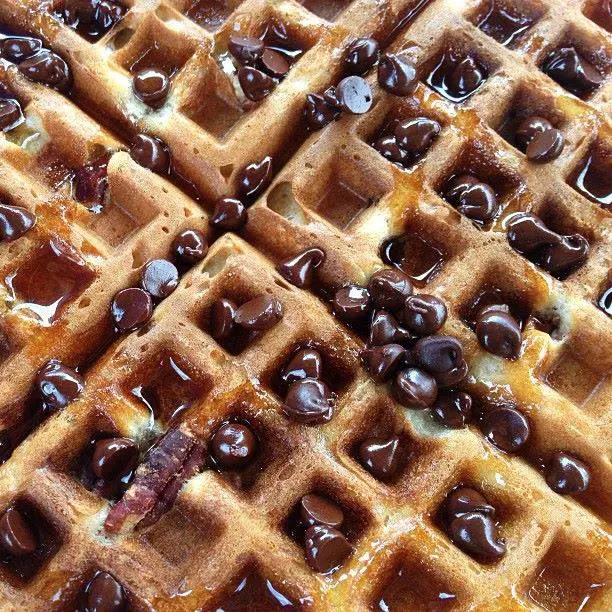 Golden waffles topped with chocolate chips and syrup