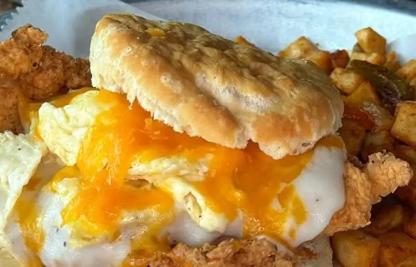 Breakfast sandwich with eggs, gravy, fried chicken, all on a buttermilk biscuit