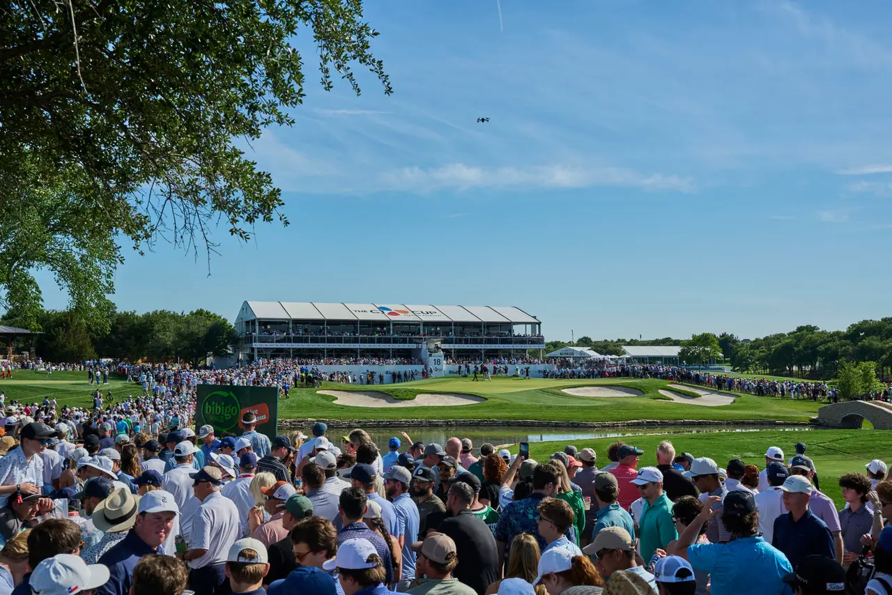 Crowd overlooking a golf course at a tournament