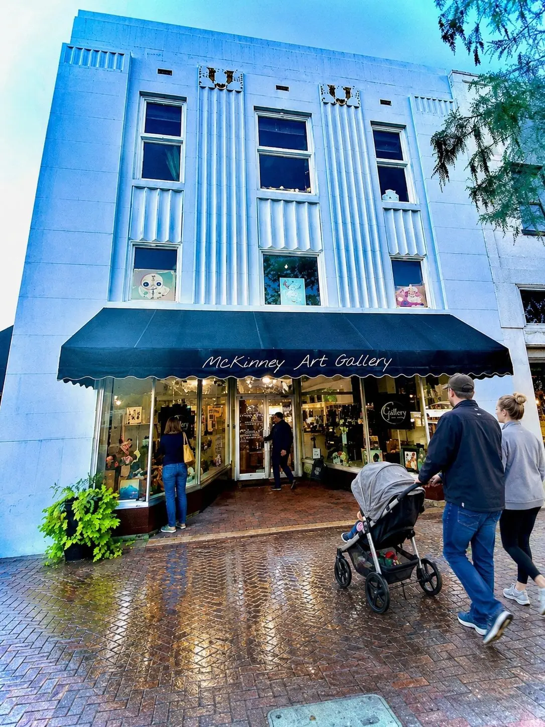 Outside of a storefront with a couple walking into a store with a stroller