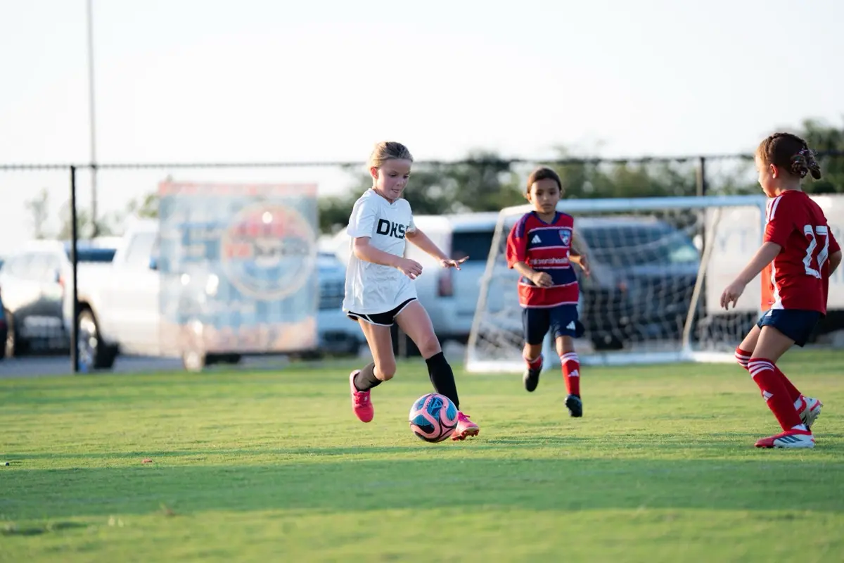 Image shows children playing soccer.