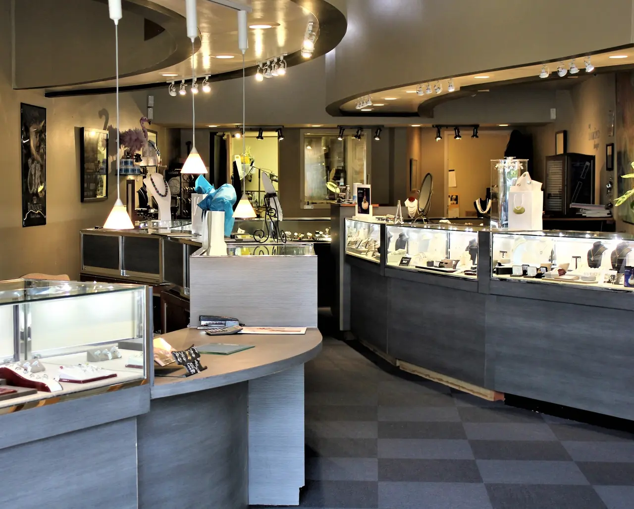 Jewelry store interior with curved display cases, pendant lighting, and merchandise displays along walls and counters