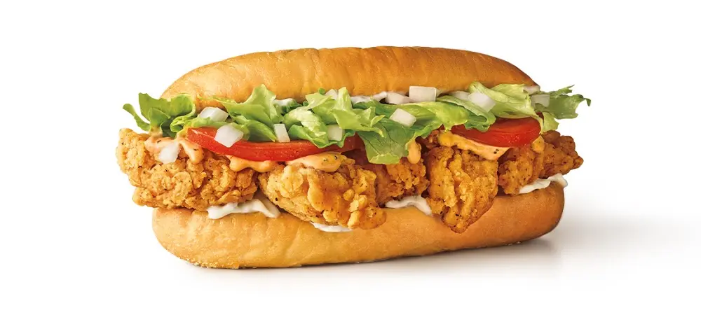 Crispy fried chicken sandwich with lettuce, tomato, and pickles on a toasted bun