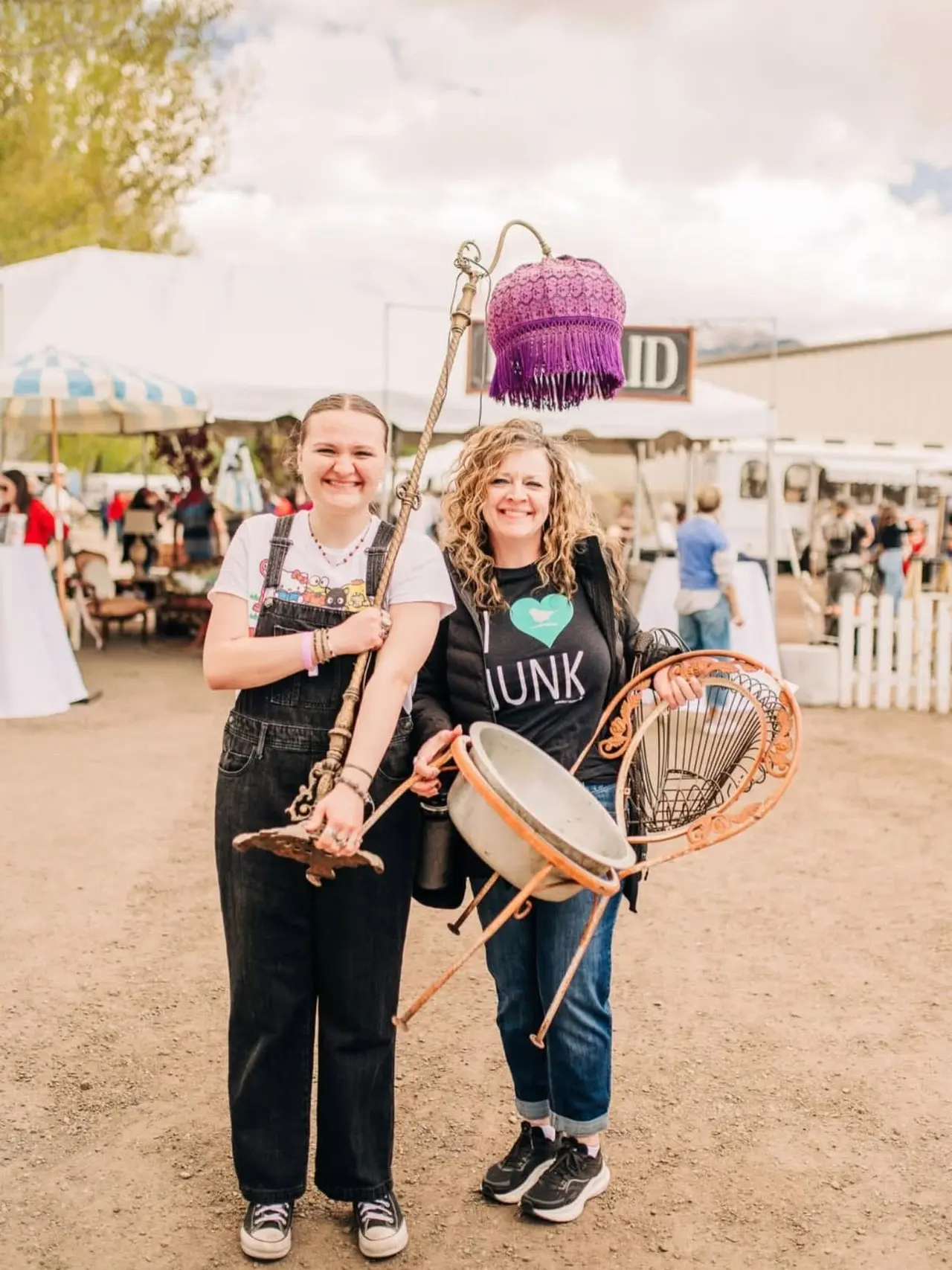 Two women holding vintage finds from a market day