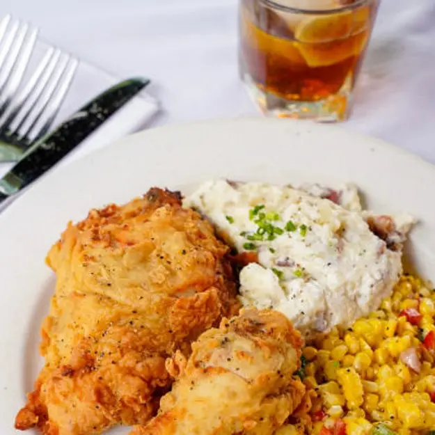 Chicken fried chicken and mashed potatoes on a plate with corn