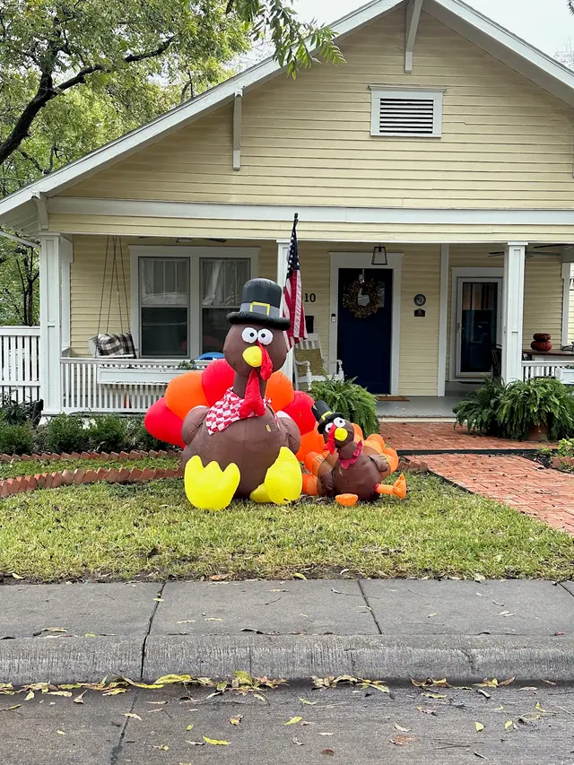 Inflatable turkey in front of a yellow historic home