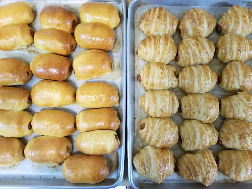 Glazed donuts and pastries arranged in two white trays