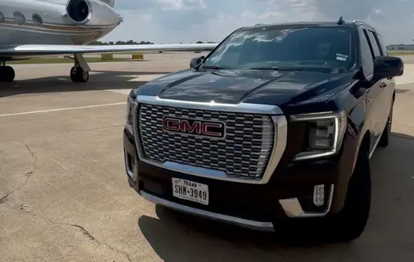 Black car with airplane in the background