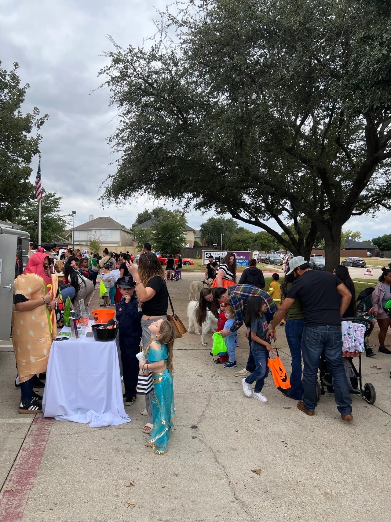 People dressed in Halloween costumes trick or treating at a trunk or treat event