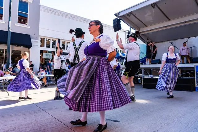 Woman dancing in front of stage in purple dress