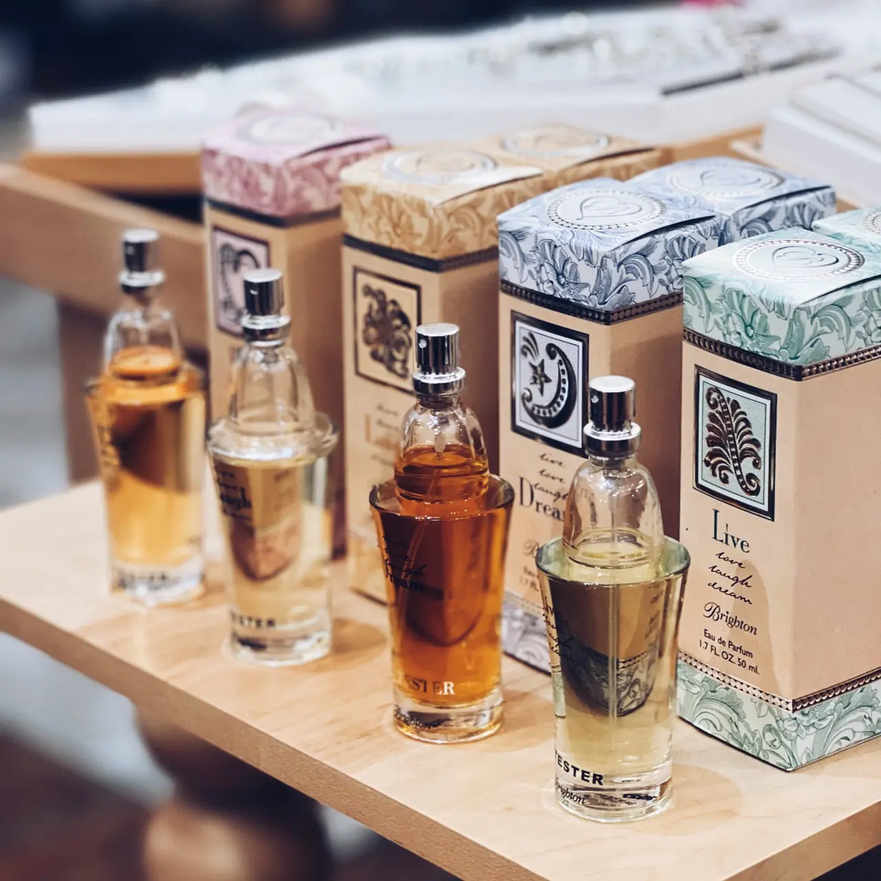 Row of liquor bottles and boxed spirits with decorative labels on wooden display surface