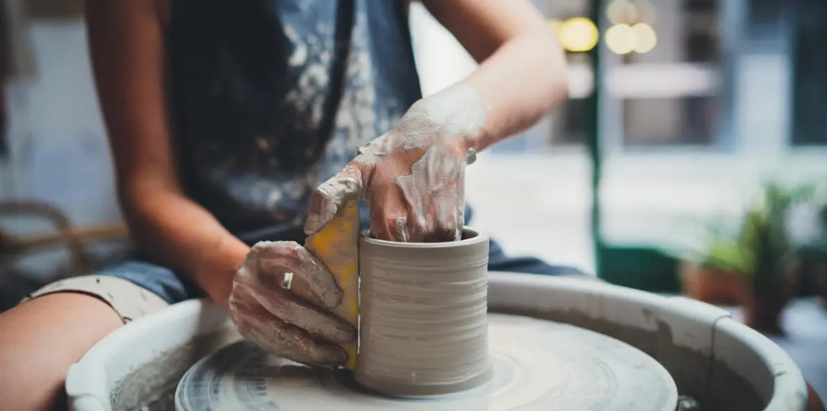 Woman working on pottery wheel