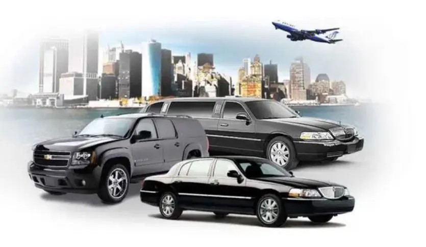 Three sedans and an SUV parked in front of a city skyline with an airplane flying overhead