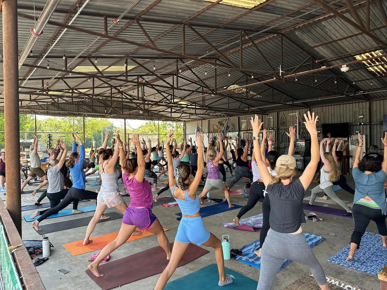 Group of people in a yoga stance in a grain room