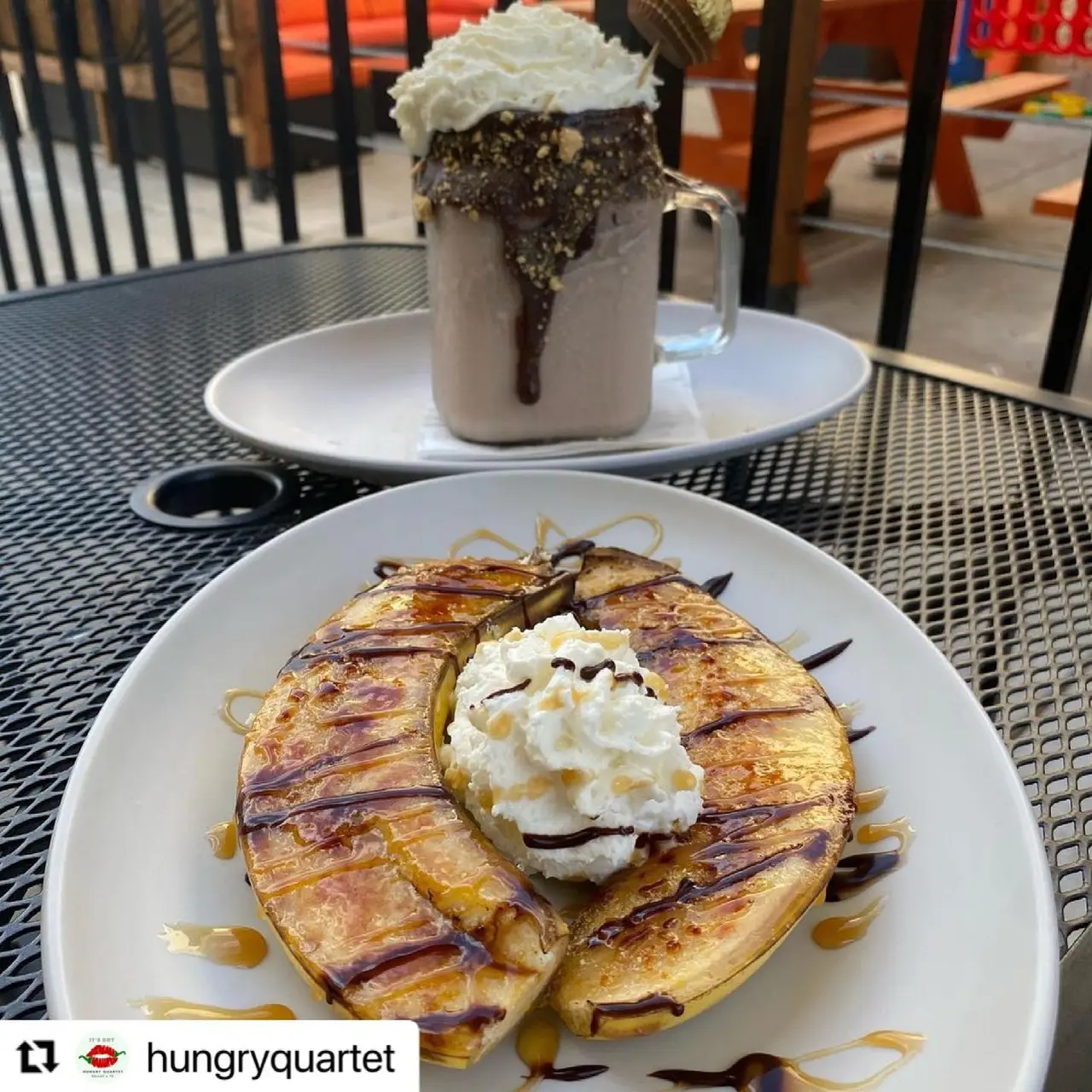 Chocolate chip pancake topped with whipped cream and chocolate drizzle, served with a chocolate mug drink topped with whipped cream