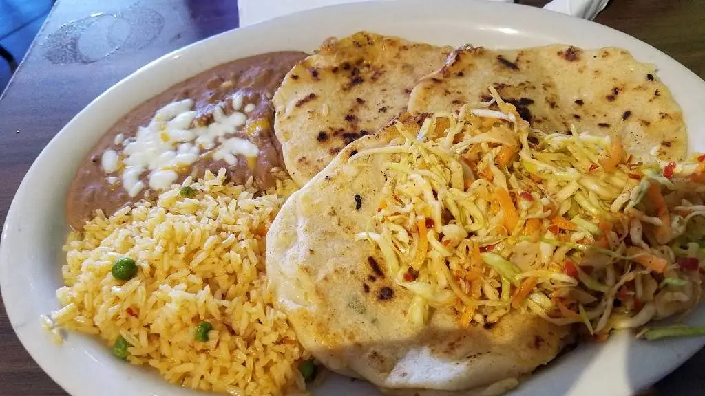 Pupusas with crispy cheese and herb filling served with yellow rice and refried beans