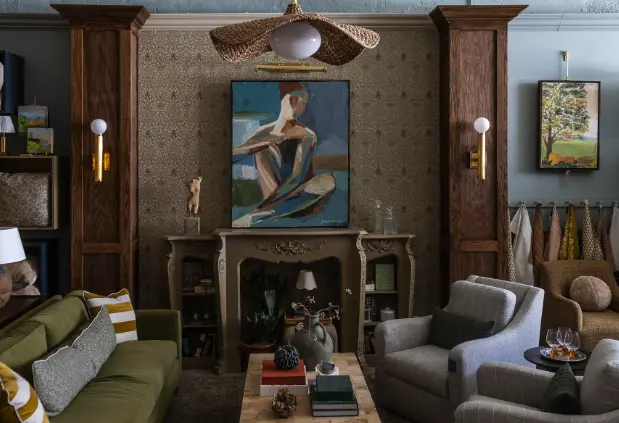 Living room with fireplace, modern art above mantel, upholstered seating, wooden built-in cabinetry, and decorative accessories