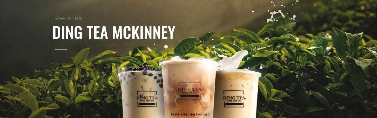 Three cups of boba tea with tapioca pearls surrounded by fresh green tea leaves
