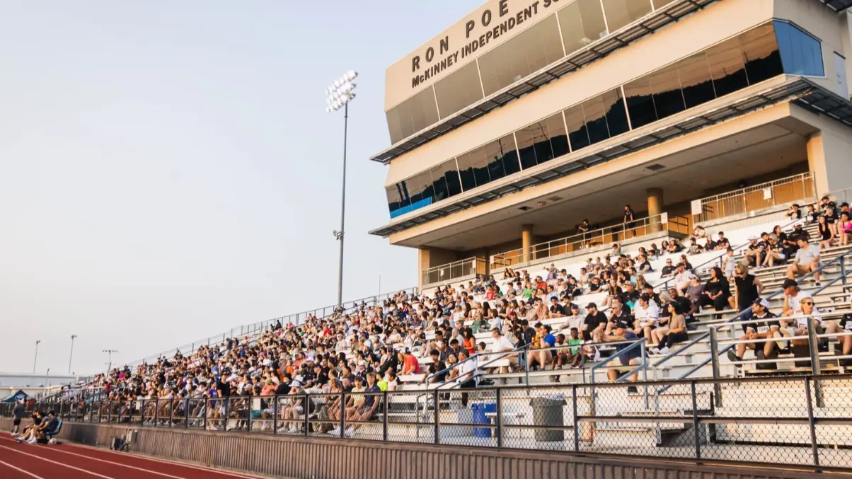 Fans in a stadium cheering on a soccer game