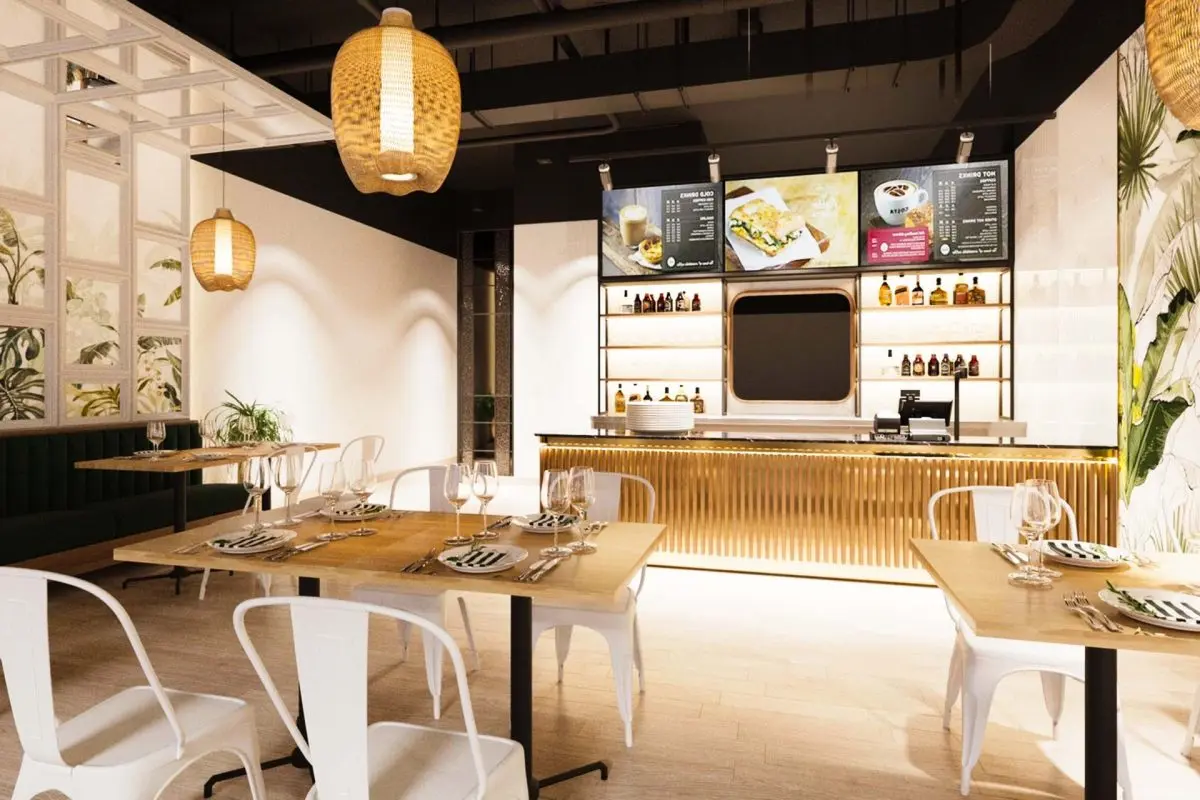 Modern Thai restaurant interior with wooden tables, white chairs, pendant lighting, and shelved bar displaying bottles and glassware