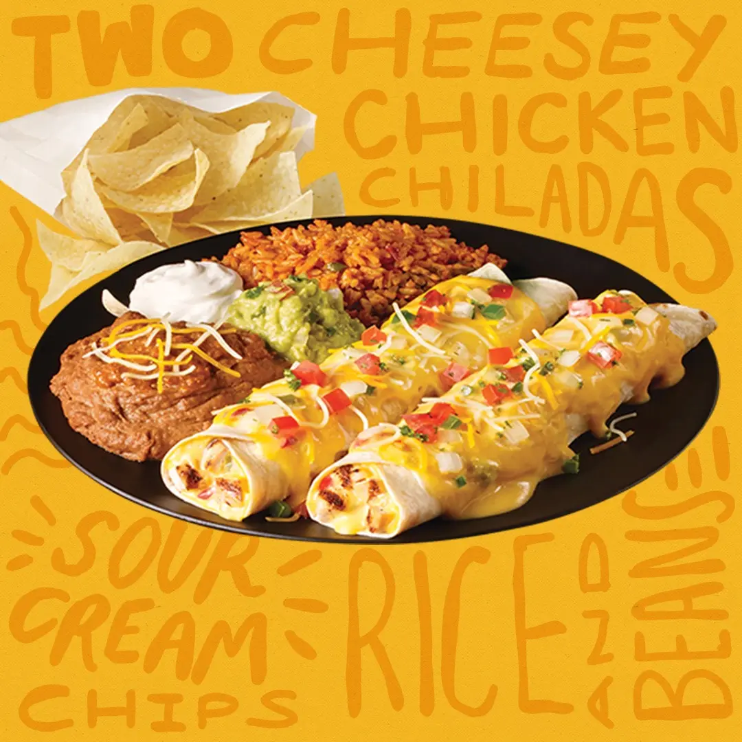 Plate with two cheese enchiladas topped with sauce and peppers, refried beans, Spanish rice, and tortilla chips with salsa