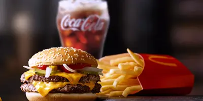 Double cheeseburger with fries and soft drink in red container