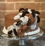 Scoops of ice cream with chocolate sauce and whipped cream in a glass bowl on a pedestal