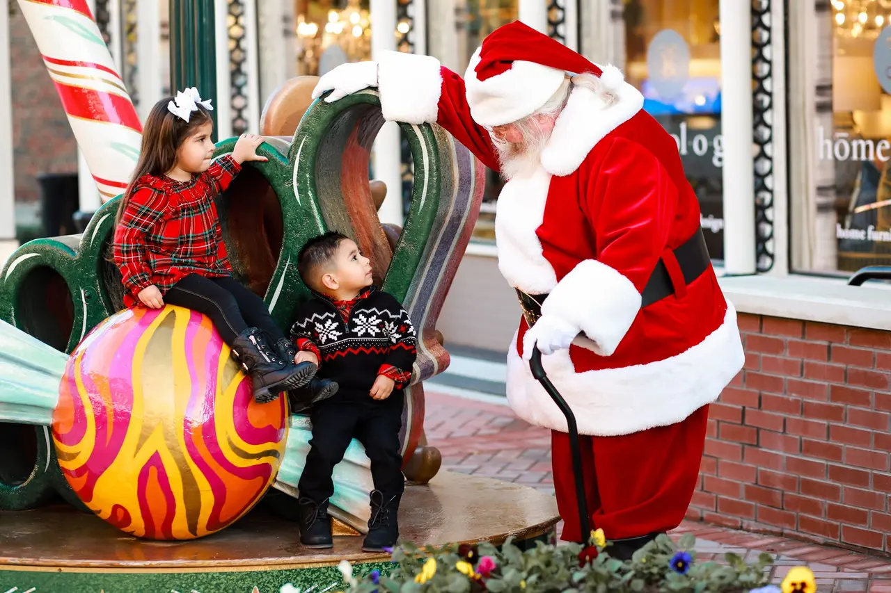 Children sitting on Christmas decor talking with Santa