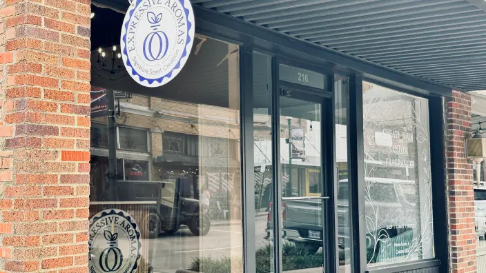 Storefront with blue and white oval signage and glass doors on red brick building