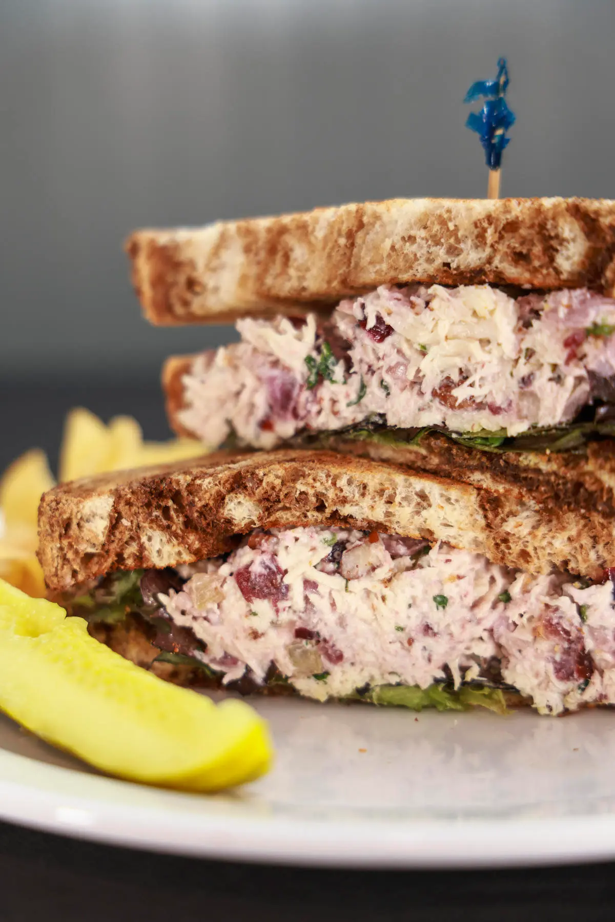 Chicken sandwich stacked high with a pickle on the side