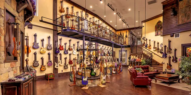 Inside of a guitar shop with guitars hung up on a wall