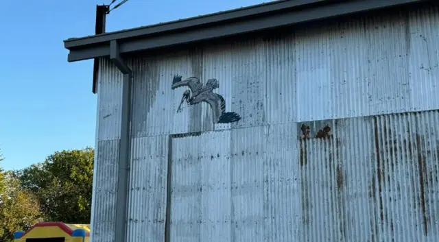 A life-sized heron mural on a corrugated-metal building in downtown McKinney