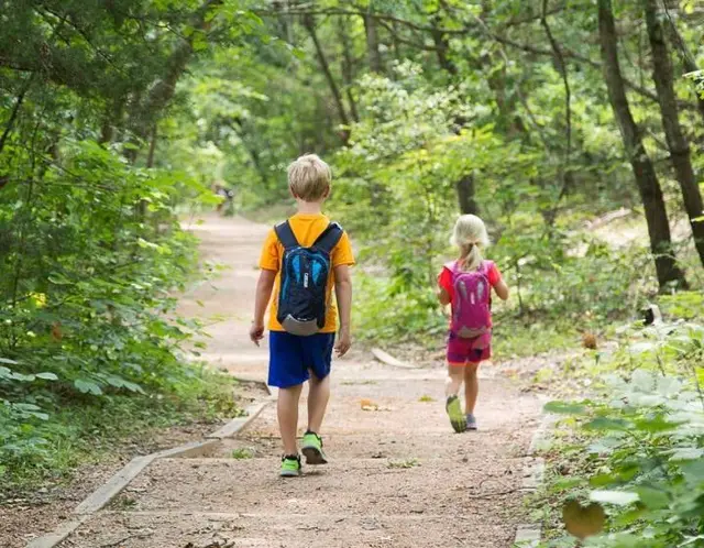 Kids walking down a wooded path at the Heard sanctuary