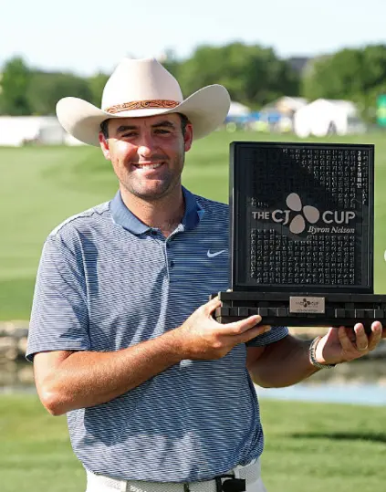 Scottie Scheffler in a white Stetson holding THE CJ CUP Byron Nelson trophy in 2025