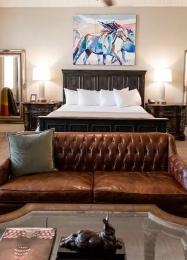 A hotel suite in McKinney with a leather couch and artwork