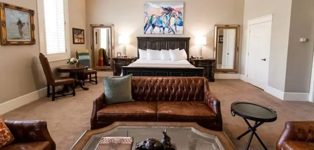 A hotel suite in McKinney with a leather couch and artwork