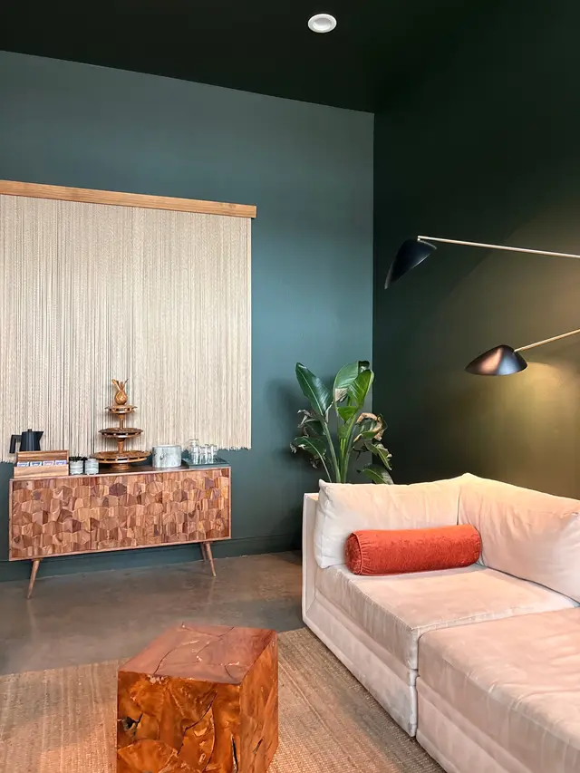 A quiet corner of a spa lounge: cream sofa, wood side table, refreshments on a sideboard