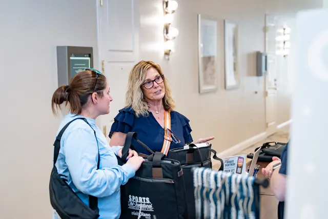 Attendees collecting bags at the S.P.O.R.T.S. The Invitational registration desk