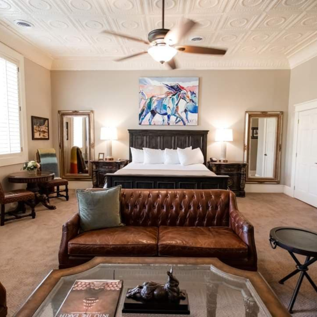A modern hotel room in McKinney with a bed, couch and artwork above the headboard